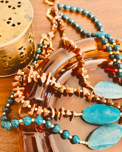 Necklace with blue beads and gold accents on a wooden surface